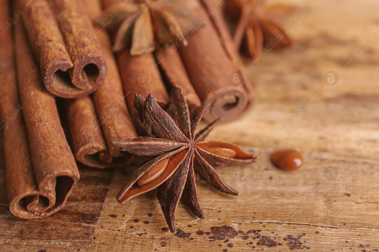 Photo of Cinnamon sticks with anise on wooden table
