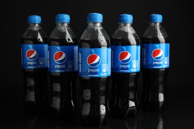 Photo of MYKOLAIV, UKRAINE - FEBRUARY 08, 2021: Plastic bottles of Pepsi with water drops on black background