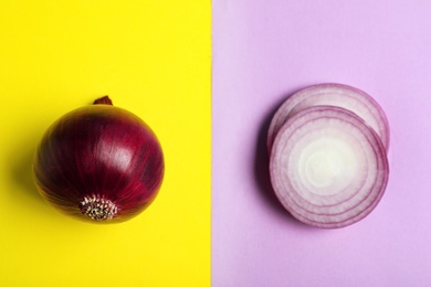 Photo of Cut and whole red onions on color background, flat lay
