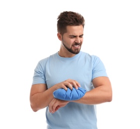 Photo of Young man with cold compress suffering from wrist pain on white background