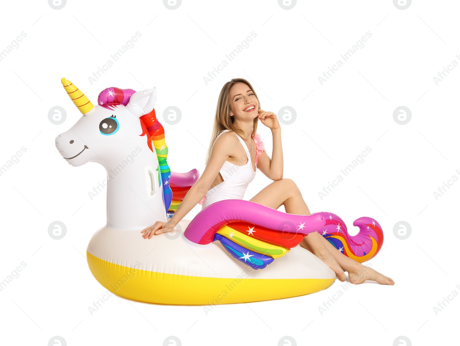 Photo of Beautiful young woman in stylish bikini with  unicorn inflatable ring on white background