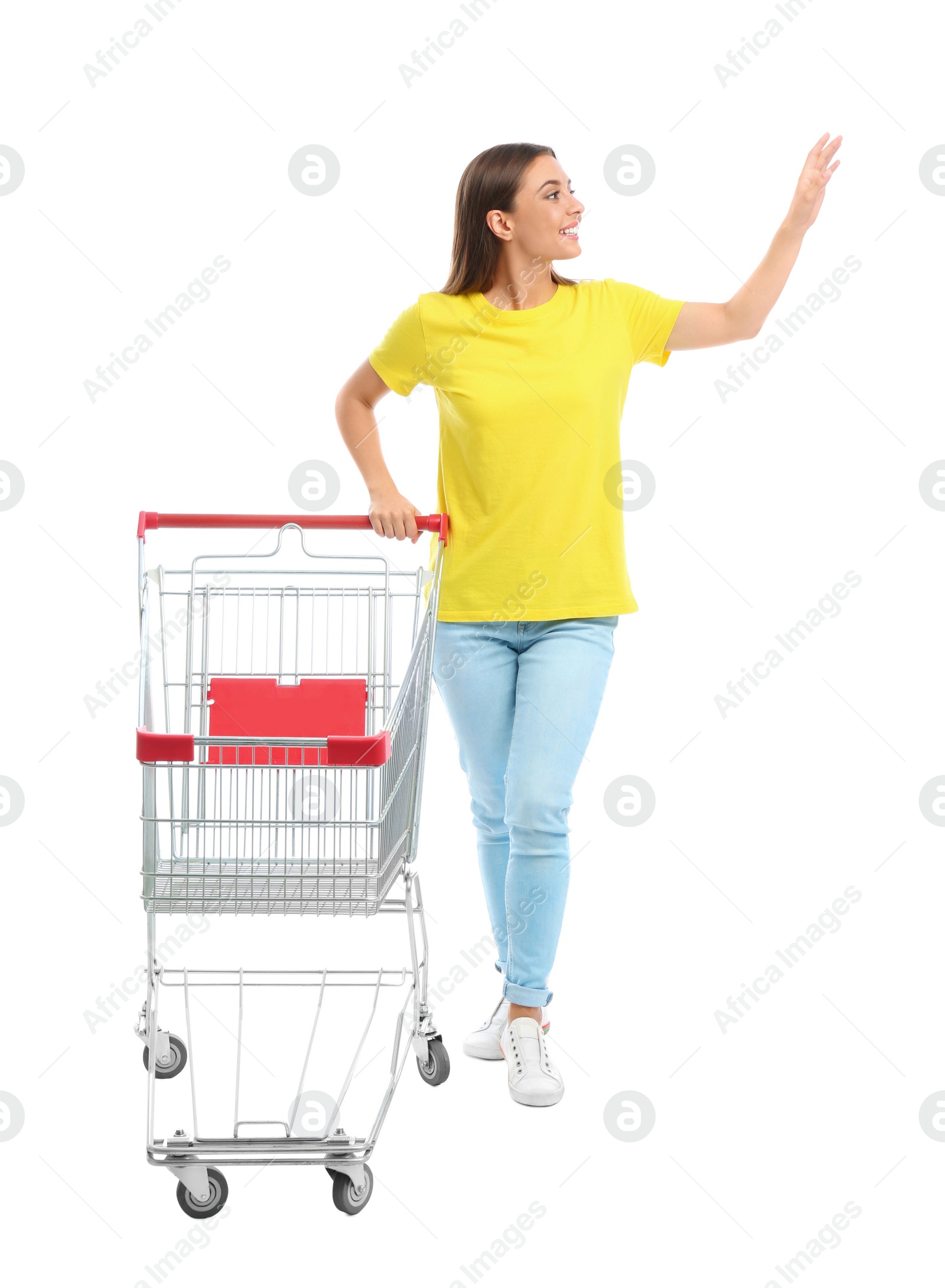 Photo of Young woman with empty shopping cart on white background