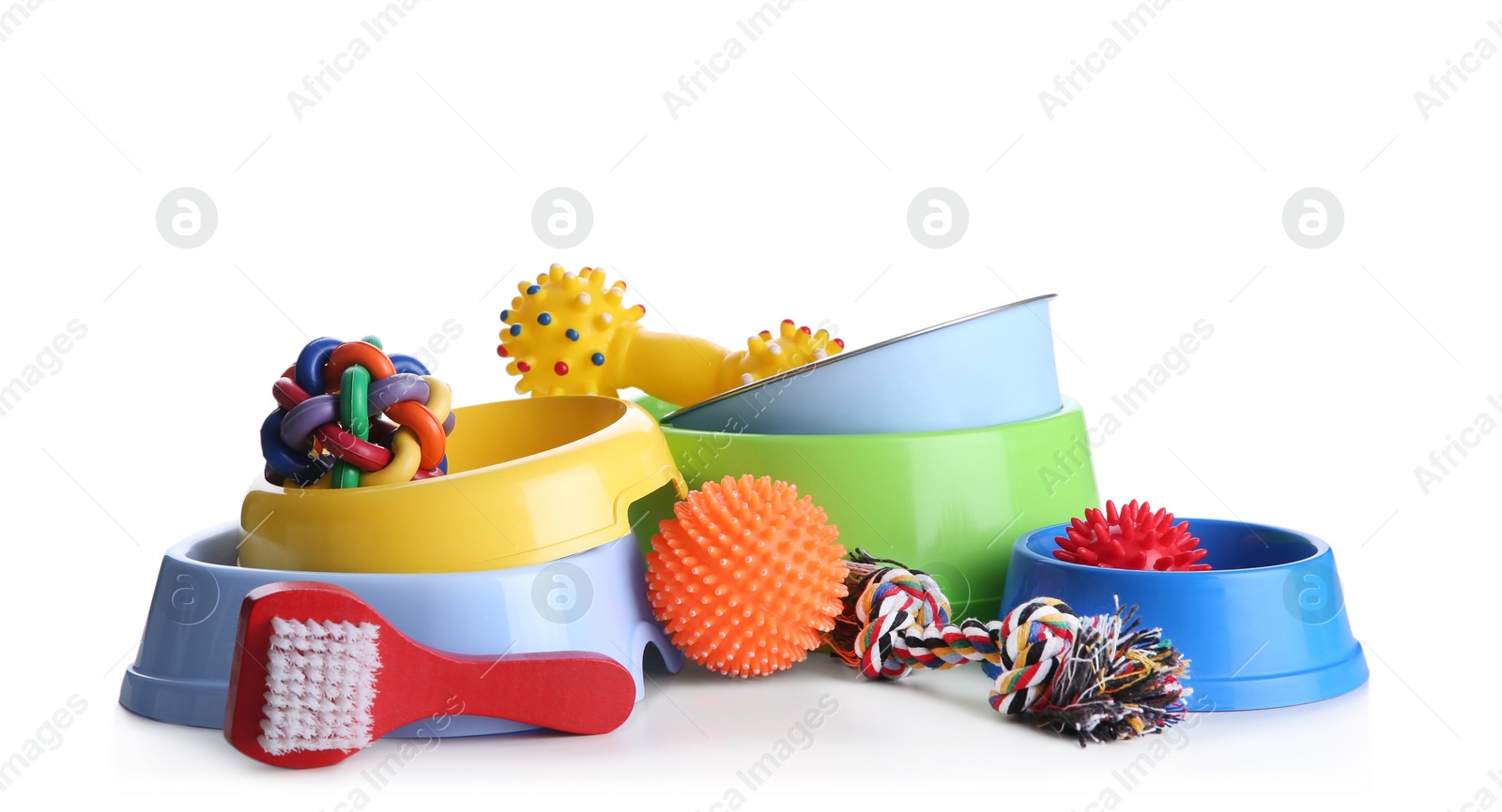 Photo of Feeding bowls, brush and dog toys on white background