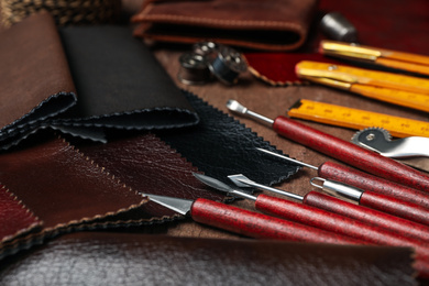 Leather samples and tools on brown table, closeup