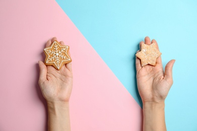 Woman holding tasty homemade Christmas cookies on color background