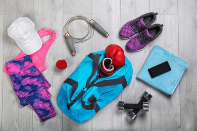 Photo of Flat lay composition with sports bag on wooden floor