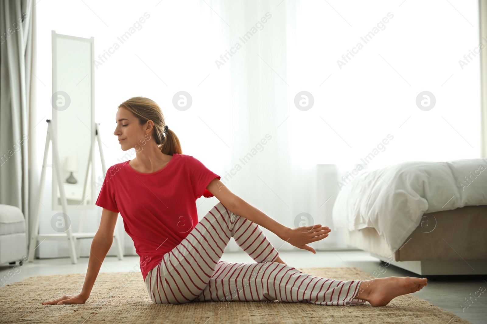 Photo of Young woman doing gymnastics on floor at home. Morning fitness
