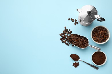 Flat lay composition with ground coffee and roasted beans on light blue background, space for text