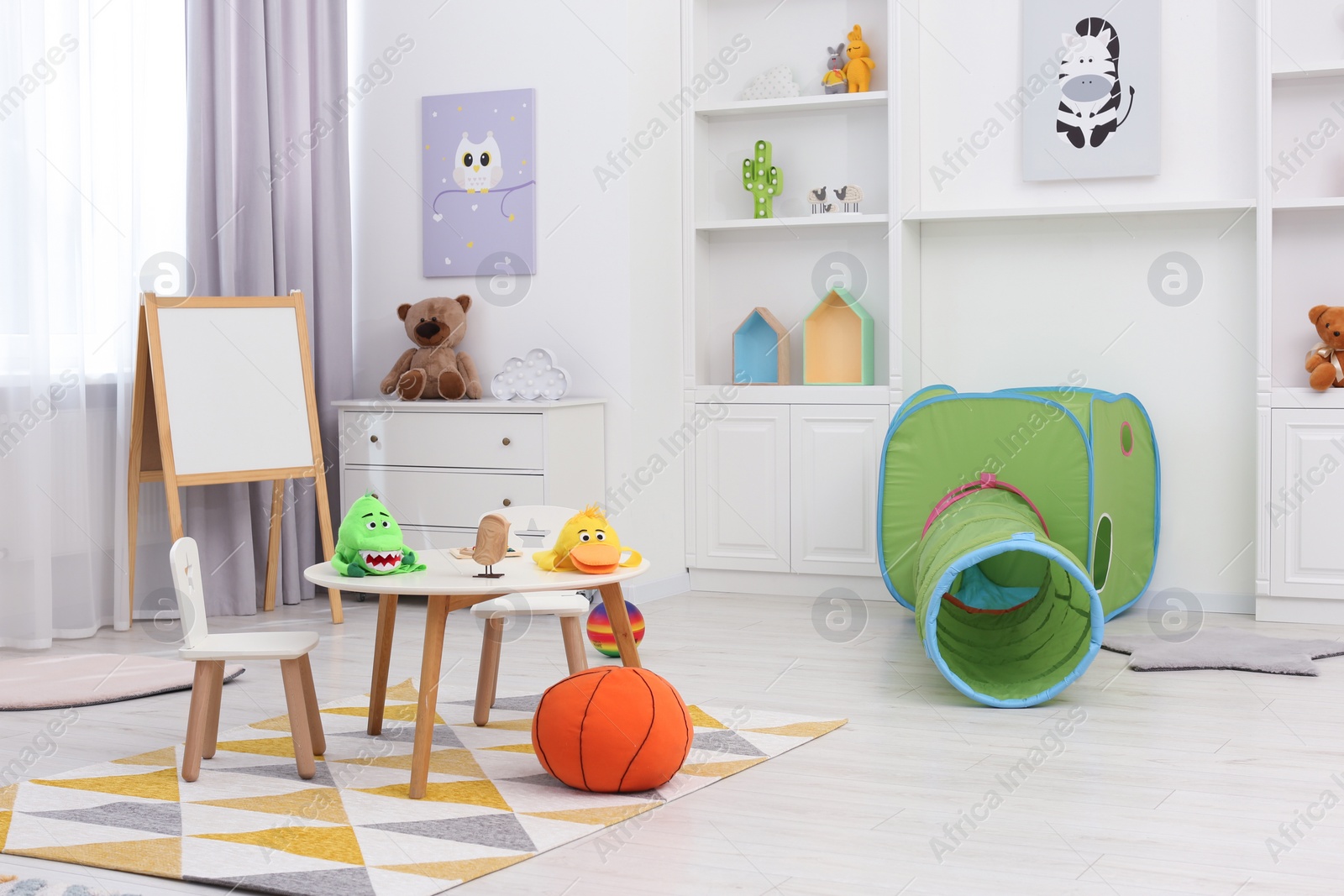 Photo of Child`s playroom with different toys and modern furniture. Stylish kindergarten interior