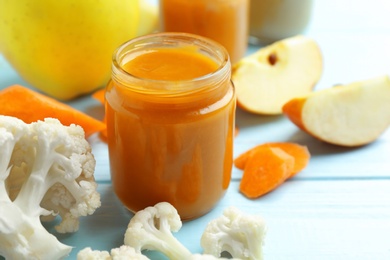 Jar with tasty baby food on table