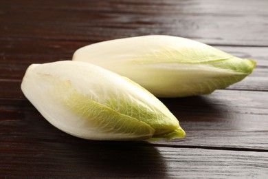 Photo of Raw ripe chicories on wooden table, closeup