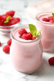 Yummy raspberry smoothie on white marble table, closeup