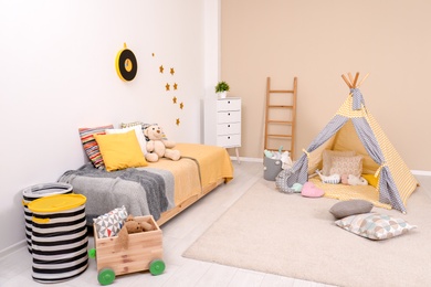 Cozy child room interior with bed, play tent and modern decor elements