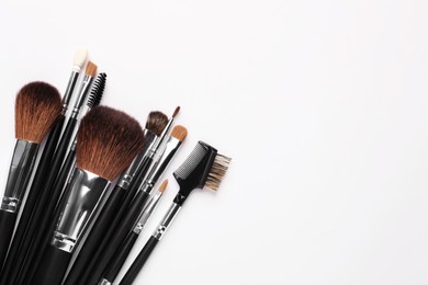 Set of makeup brushes on white background, flat lay. Space for text