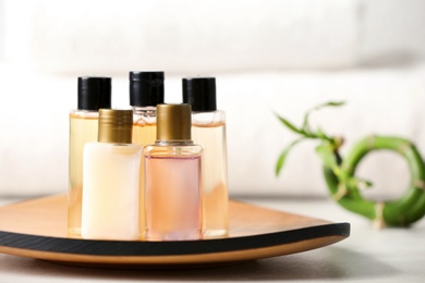 Mini bottles with cosmetic products and towels on table, space for text. Hotel amenities