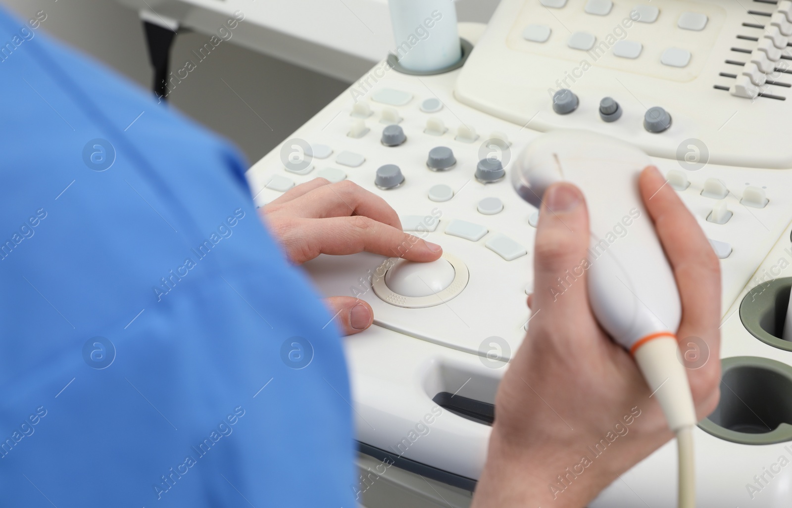 Photo of Sonographer operating modern ultrasound machine in clinic, closeup