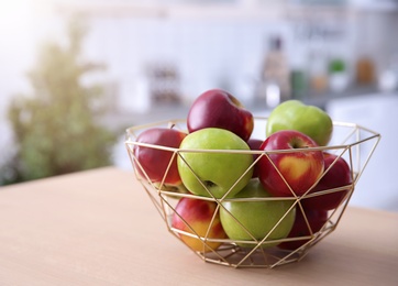 Ripe apples in decorative bowl on table