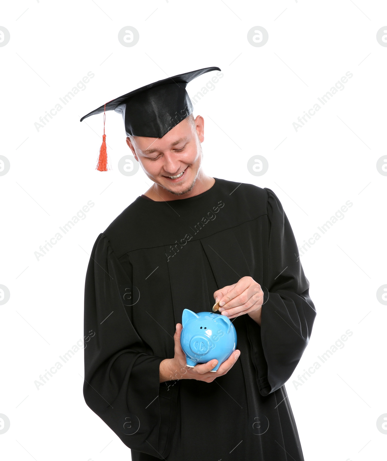 Photo of Portrait of young graduate putting coin into piggy bank on white background