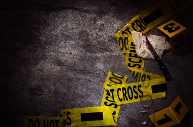 Photo of Flat lay composition with evidences and crime scene tape on grey stone background, space for text