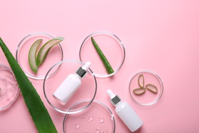 Photo of Flat lay composition with aloe vera leaves and cosmetic products on pink background. Space for text