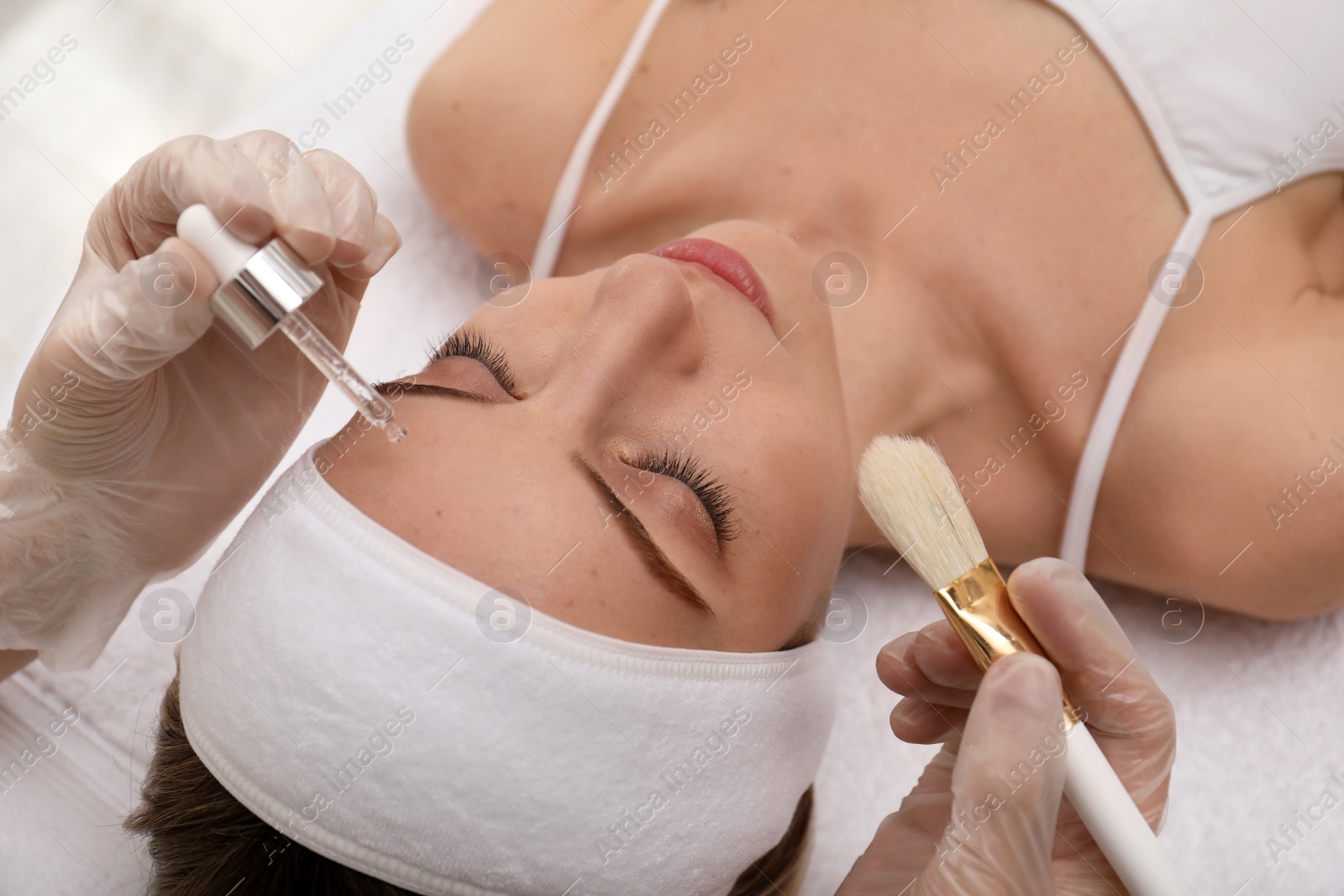 Photo of Young woman during face peeling procedure in salon