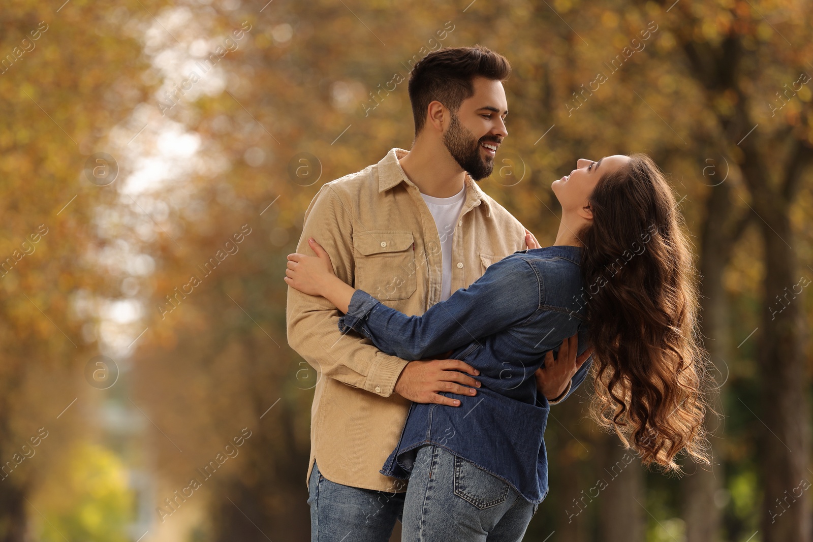 Photo of Beautiful couple spending time together in autumn park, space for text