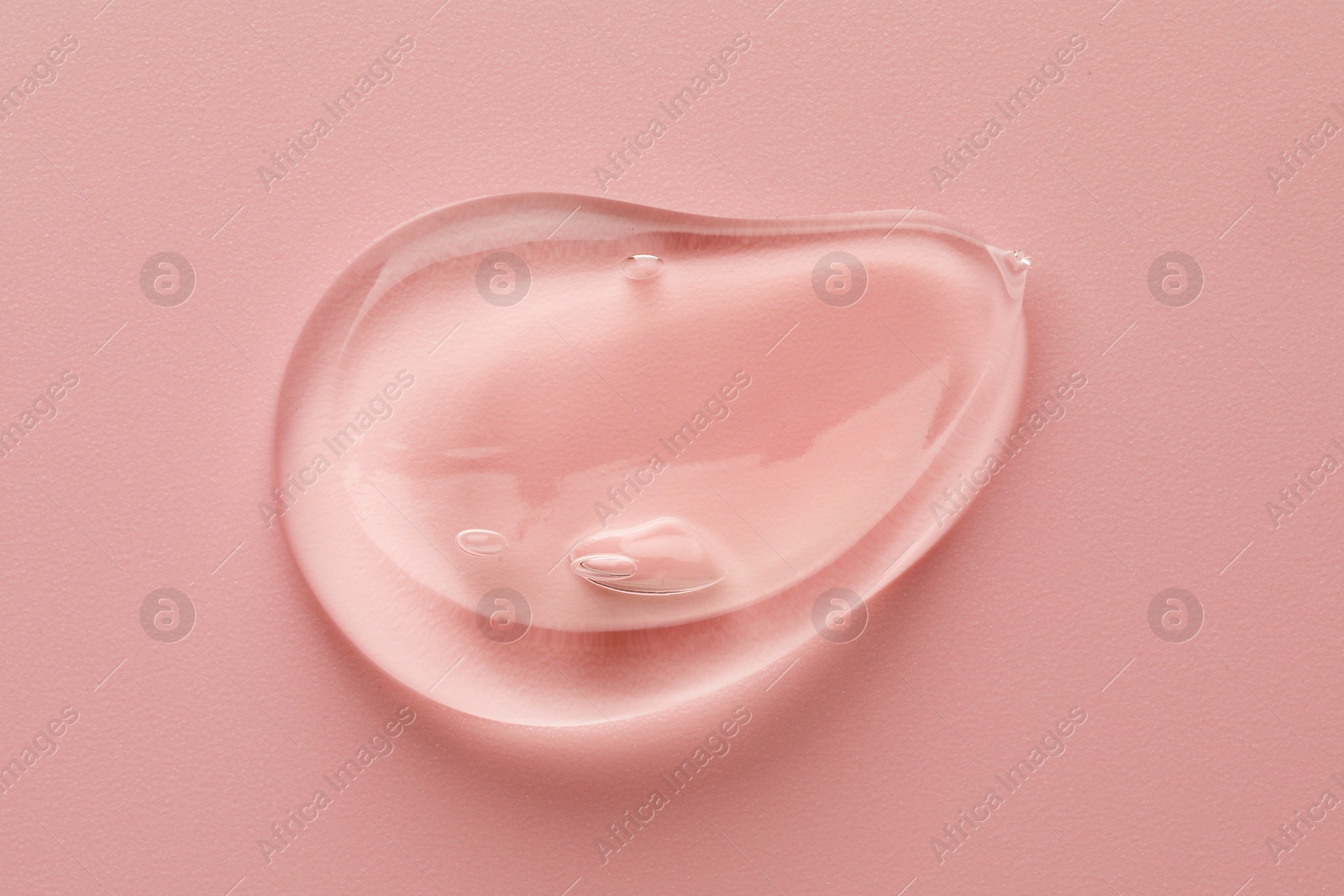 Photo of Smear of clear cosmetic gel on pink background, top view