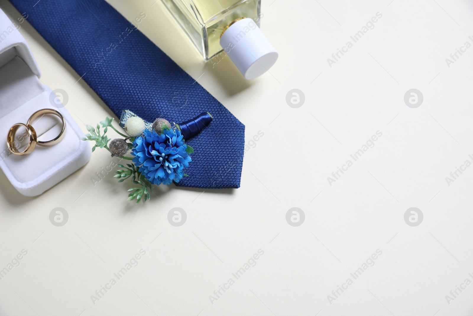 Photo of Wedding stuff. Composition with stylish boutonniere on light background, above view. Space for text