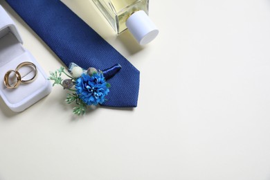 Photo of Wedding stuff. Composition with stylish boutonniere on light background, above view. Space for text