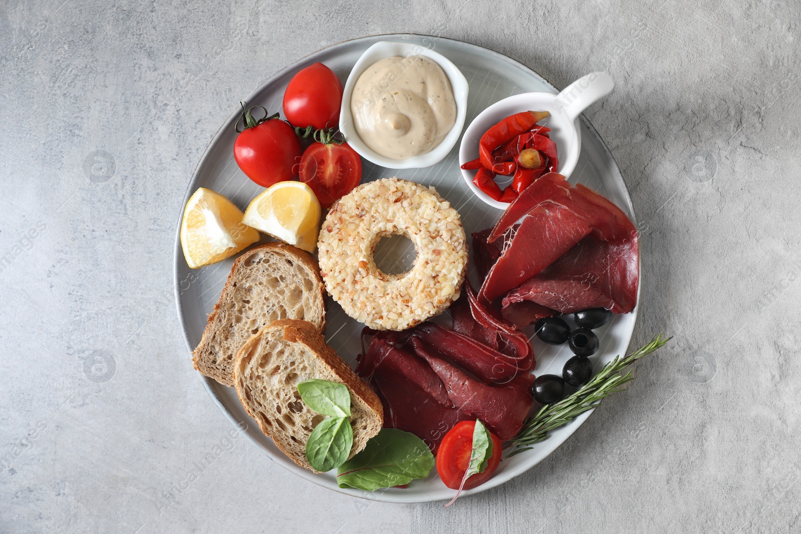 Photo of Delicious bresaola and other ingredients for sandwich on light table, top view
