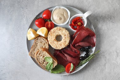 Delicious bresaola and other ingredients for sandwich on light table, top view