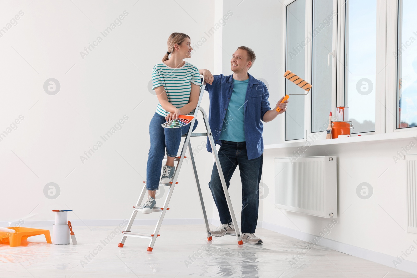 Photo of Happy couple discussing interior details in apartment during repair