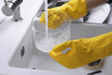 Photo of Woman washing glass pot in kitchen sink, closeup