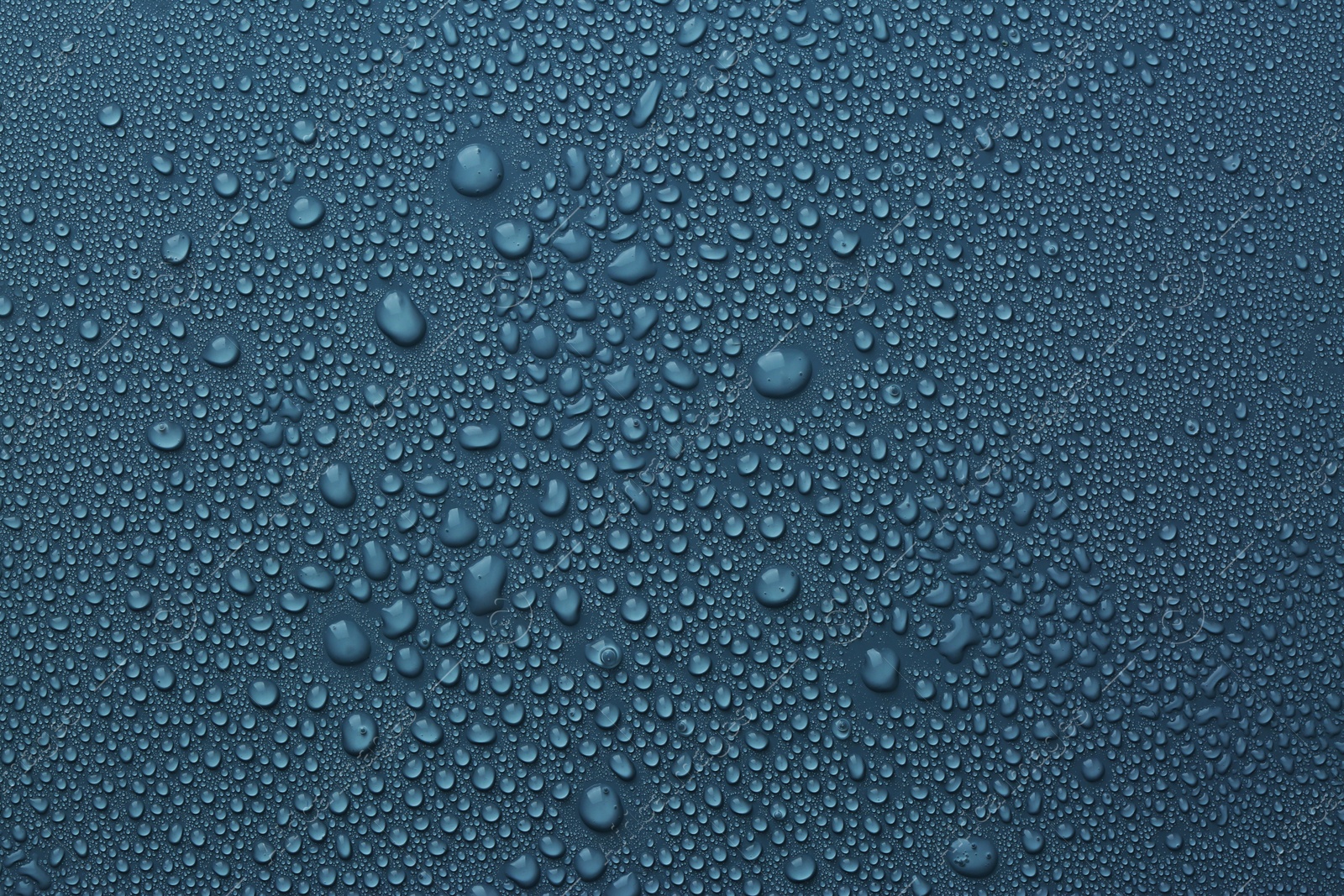 Photo of Many water drops on dark dusty blue background