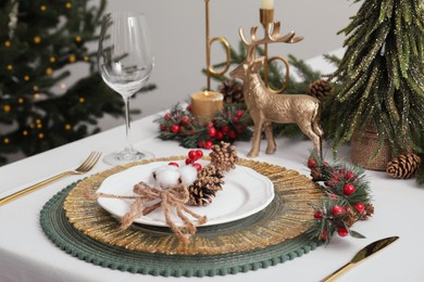 Photo of Luxury festive place setting with beautiful decor for Christmas dinner on white table indoors