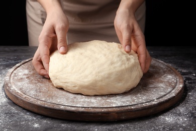 Female baker preparing bread dough at table, closeup