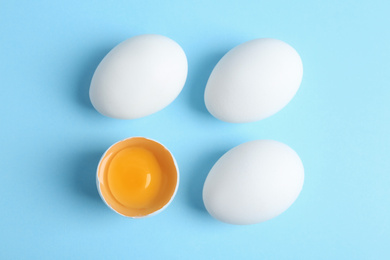 Photo of Fresh raw chicken eggs on light blue background, flat lay