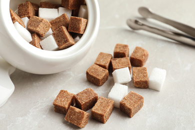 Bowl and refined sugar cubes on light table, closeup