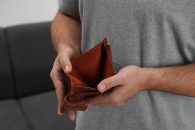 Photo of Man with empty wallet at home, closeup