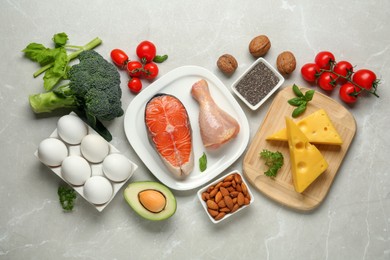 Flat lay composition with keto diet products on light grey marble table