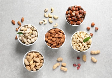 Flat lay composition with organic nuts on grey background, top view. Snack mix