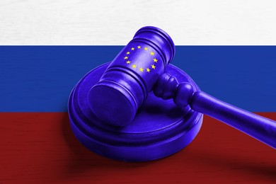 Image of Economic sanctions against Russia because of invasion in Ukraine. Judge's gavel in color of European flag on background in color of Russian flag