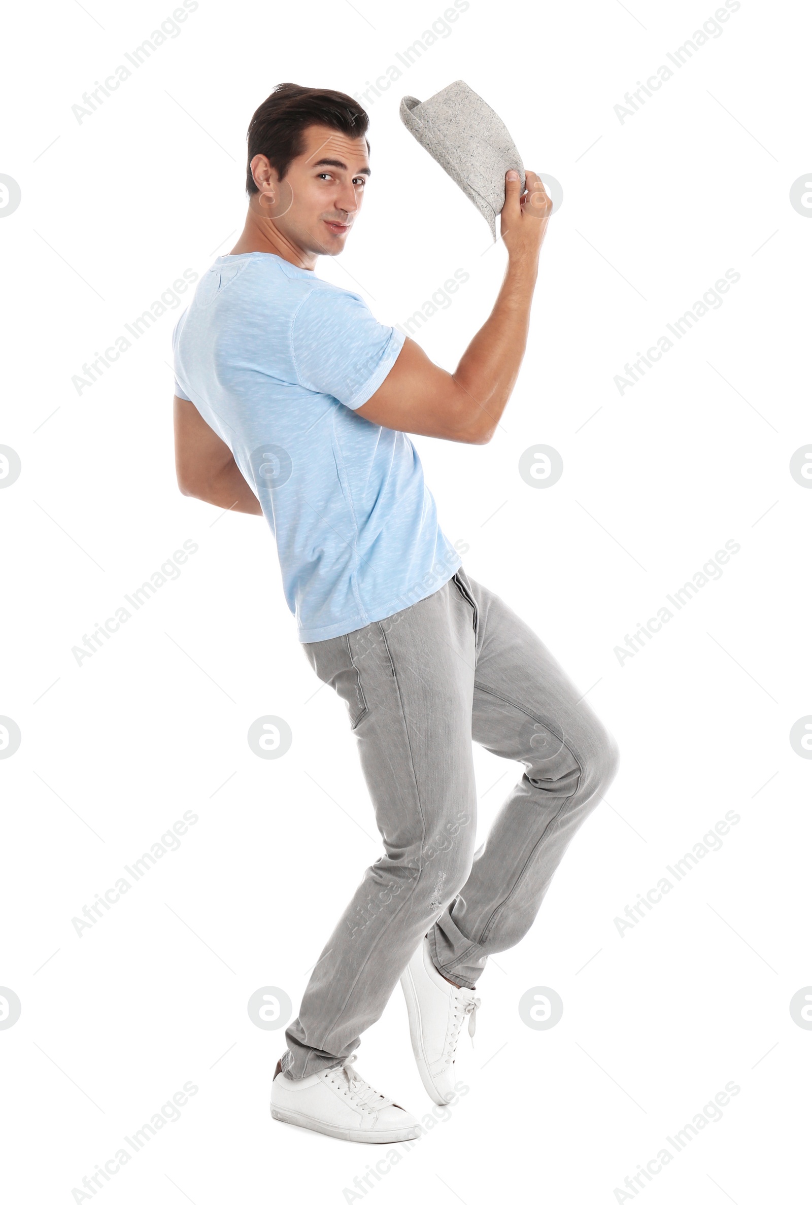 Photo of Handsome young man with hat dancing on white background