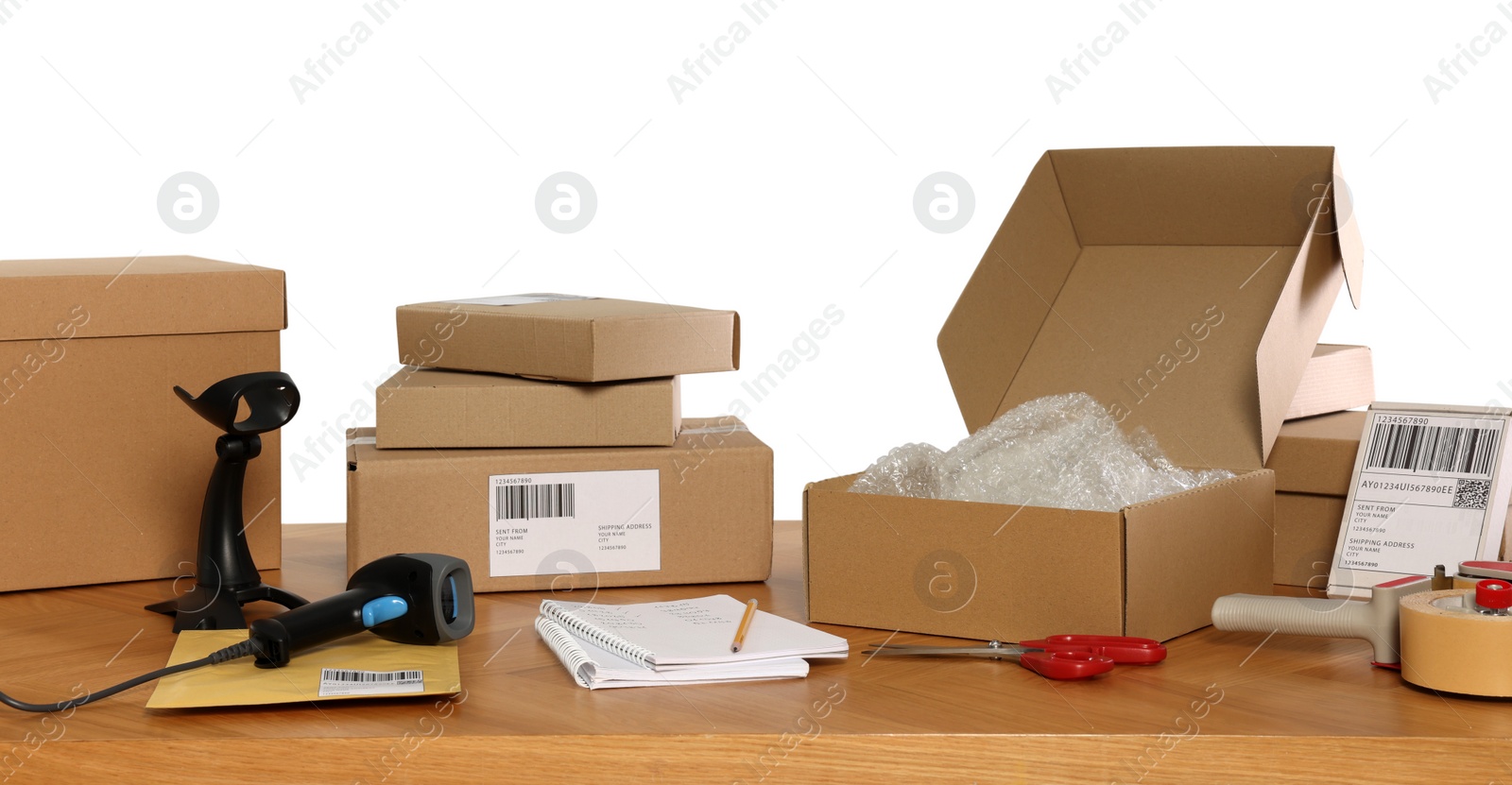 Photo of Parcels, barcode scanner and stationary on wooden table against white background. Online store