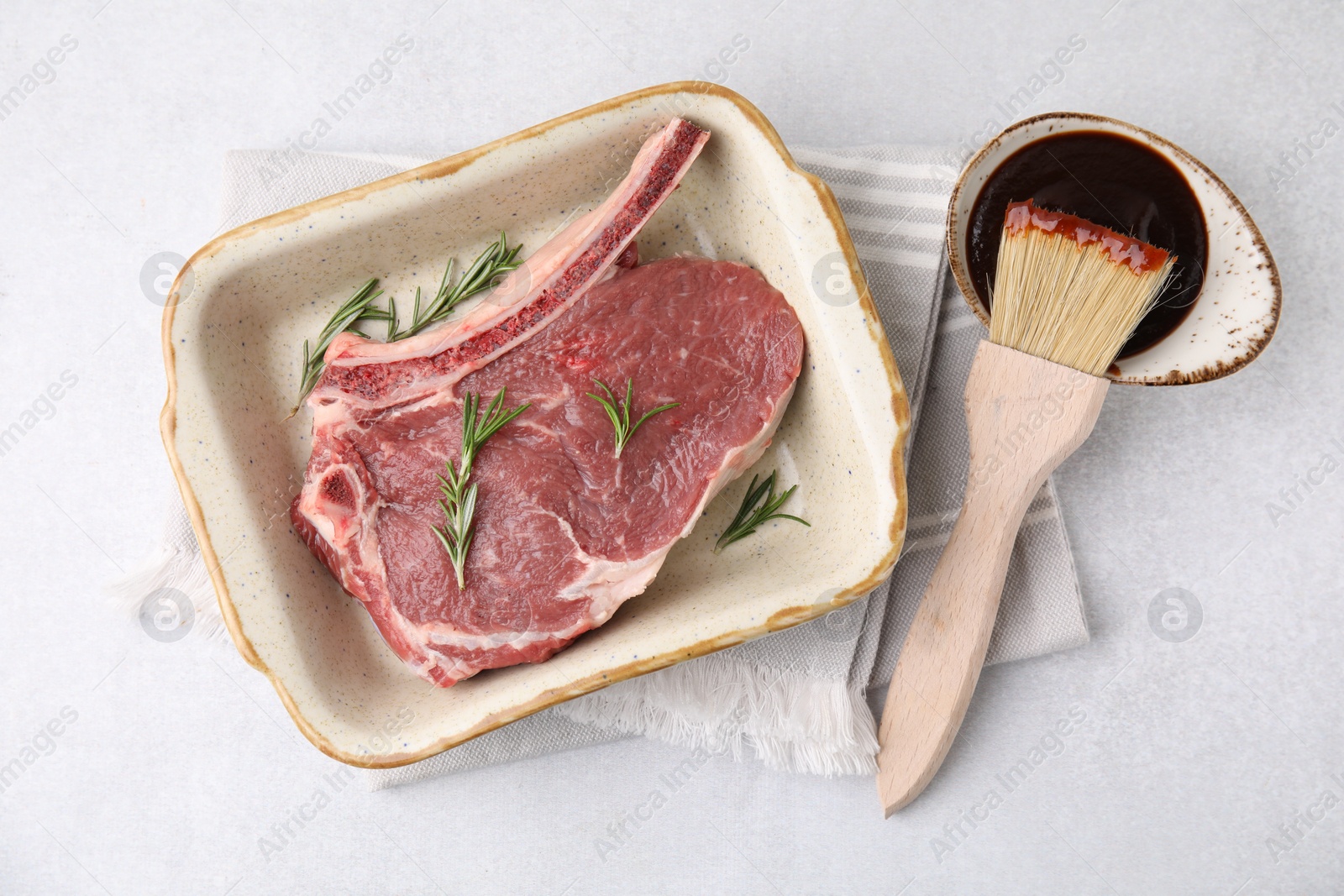 Photo of Raw meat, rosemary and marinade on light table, top view