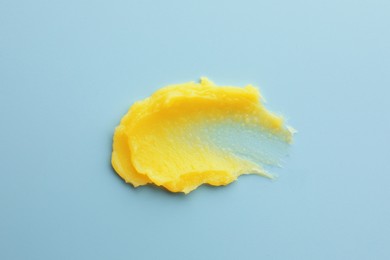Sample of face scrub on light blue background, top view