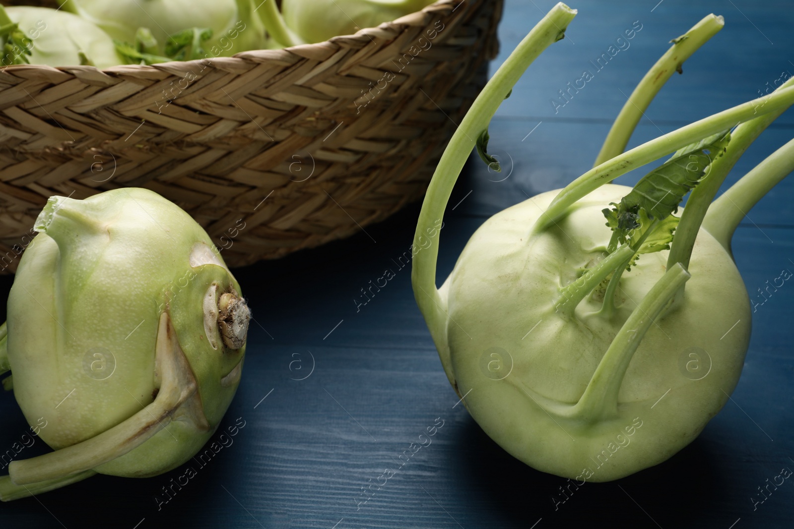 Photo of Whole ripe kohlrabi plants on blue wooden table