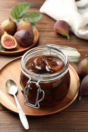 Jar of tasty sweet jam and fresh figs on wooden table