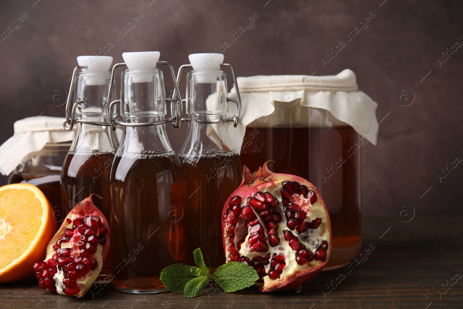 Photo of Tasty kombucha, mint and fresh fruits on wooden table