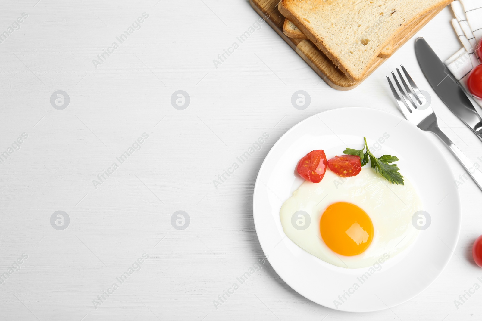 Photo of Tasty fried egg served with bread on white wooden table, flat lay. Space for text